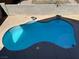Aerial view of a uniquely-shaped pool, gray stone landscaping, and a privacy wall at 9328 Jumpin Juniper Ave, Las Vegas, NV 89129