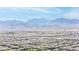 Expansive aerial view of a community nestled against a stunning mountain backdrop, featuring rows of homes under a clear sky at 9527 Havasu Canyon Ave, Las Vegas, NV 89166