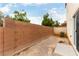 A backyard with a concrete block wall, desert landscaping, and sliding glass doors to the interior at 9527 Havasu Canyon Ave, Las Vegas, NV 89166