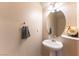 This bathroom features a pedestal sink, an oval mirror, and neutral walls at 9527 Havasu Canyon Ave, Las Vegas, NV 89166