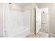 Bathroom with white tiled shower and tub, tile flooring, and an open door at 9527 Havasu Canyon Ave, Las Vegas, NV 89166