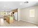 Bright kitchen featuring tile flooring, island, white appliances and wood cabinets at 9527 Havasu Canyon Ave, Las Vegas, NV 89166