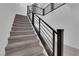 Carpeted stairs with modern, black metal railing leading to the second floor at 9795 Bold Skye Ave, Las Vegas, NV 89166