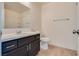 A clean bathroom features a black vanity cabinet and a large, well-lit mirror at 9944 Swimming Hole St, Las Vegas, NV 89183