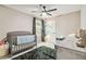 Cozy bedroom with crib, ceiling fan, and natural light from a window at 10190 Natural Anchor St, Las Vegas, NV 89166