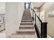 Carpeted staircase with a modern black railing, leading to the upper level of the home at 10190 Natural Anchor St, Las Vegas, NV 89166