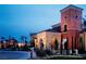 Beautiful community clubhouse featuring Mediterranean architecture and lush landscaping at dusk at 10239 Premia Pl, Las Vegas, NV 89135