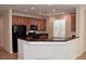 Well-lit eat-in kitchen featuring a granite breakfast bar, dark appliances, wood cabinets, and recessed lights at 10239 Premia Pl, Las Vegas, NV 89135