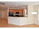 Modern kitchen featuring wood cabinets, a granite countertop breakfast bar, recessed lighting, and stainless steel appliances at 10239 Premia Pl, Las Vegas, NV 89135