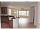 Eat-in kitchen featuring granite counters and wood cabinets leading to a large sitting room with bright windows at 10239 Premia Pl, Las Vegas, NV 89135