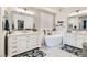 Bright bathroom featuring double vanity, soaking tub, large mirrors and decorative rugs at 1049 Via Saint Lucia Pl, Henderson, NV 89011