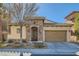 Charming single-story home featuring a stone facade, arched entry, and a two-car garage at 1049 Via Saint Lucia Pl, Henderson, NV 89011