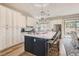 Bright kitchen with a large island, white cabinets, and modern pendant lighting fixtures at 1049 Via Saint Lucia Pl, Henderson, NV 89011