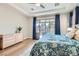 Bright main bedroom featuring wood floors, a ceiling fan, and glass slider to the patio at 1049 Via Saint Lucia Pl, Henderson, NV 89011