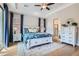 Bright main bedroom featuring a tray ceiling, wood floors, and an ensuite bathroom with a glass slider to the patio at 1049 Via Saint Lucia Pl, Henderson, NV 89011