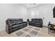 Living room featuring black leather sofas and a stylish rug, creating a welcoming atmosphere at 116 Juliette Pointe Ln, Henderson, NV 89011