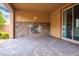 Inviting covered back patio with stone fireplace and sliding glass doors at 12240 Old Muirfield St, Las Vegas, NV 89141