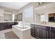 Bathroom features a drop-in tub, dark wood cabinets with double sinks and white countertop at 12240 Old Muirfield St, Las Vegas, NV 89141