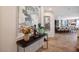 The foyer is decorated with tiled floors, a console table with vase of flowers, and a mirror at 12240 Old Muirfield St, Las Vegas, NV 89141