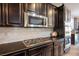 The kitchen is beautifully appointed with black cabinets, granite countertop, and stainless appliances at 12240 Old Muirfield St, Las Vegas, NV 89141