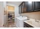 Functional laundry room with white washer and dryer, a sink, and ample cabinet space for storage at 12240 Old Muirfield St, Las Vegas, NV 89141