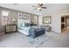 Spacious main bedroom featuring neutral decor, a ceiling fan, and a cozy seating area at 12240 Old Muirfield St, Las Vegas, NV 89141