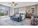 Spacious main bedroom boasts a ceiling fan, neutral carpet, stylish furnishings, and balcony access at 12240 Old Muirfield St, Las Vegas, NV 89141