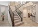 Elegant staircase with dark railing and carpeted steps, leading to the upper level of the home at 12240 Old Muirfield St, Las Vegas, NV 89141