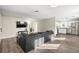 Bright living room featuring wood floors, a modern sectional couch, and an open layout to the kitchen at 1516 Saylor Way, Las Vegas, NV 89108