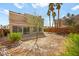 Backyard with brick pavers, a low block wall, some shrubbery, and a view of palm trees at 1904 Monte Alban Dr, North Las Vegas, NV 89031