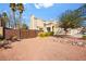 A tranquil home exterior featuring a stucco wall, tile roof, and mature trees at 1904 Monte Alban Dr, North Las Vegas, NV 89031