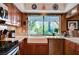 Bright kitchen boasts wooden cabinets, granite counters, and a farmhouse sink underneath a sunlit window at 1905 Calle De Espana, Las Vegas, NV 89102