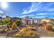 Inviting front exterior of a single-story home featuring a red door, desert landscaping, and a sunny curb appeal at 2129 N Michael Way, Las Vegas, NV 89108