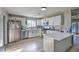 Bright kitchen features white cabinets, stainless steel appliances, and light wood-look floors at 2129 N Michael Way, Las Vegas, NV 89108