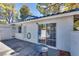 Back patio features white brick, windows, a security door, and a sliding glass door for indoor/outdoor living at 2141 Twickenham Pl # A, Las Vegas, NV 89108