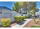 Single-story home featuring desert landscaping, blue-tiled roof, white brick walls, and a sidewalk entrance at 2141 Twickenham Pl # A, Las Vegas, NV 89108