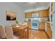 An eat-in kitchen with white appliances, stone countertops, and wood-look laminate flooring at 2141 Twickenham Pl # A, Las Vegas, NV 89108