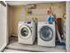 Laundry room with a pair of front load Samsung washing machines and storage shelving at 2141 Twickenham Pl # A, Las Vegas, NV 89108