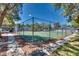 Outdoor tennis court surrounded by trees and fencing on a sunny day at 2141 Twickenham Pl # A, Las Vegas, NV 89108