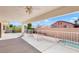 Backyard covered patio with tile floors, white fencing and view of neighbors homes and landscaping at 2161 Avalon Dr, Laughlin, NV 89029