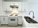 A kitchen with white cabinetry, stone counters, and modern fixtures at 2525 Sierra Bello Ave # 103, Las Vegas, NV 89106