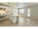 Open concept kitchen showcasing a kitchen island with stainless sink and tile flooring at 2525 Sierra Bello Ave # 103, Las Vegas, NV 89106