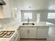 Kitchen showcasing a kitchen island with stainless sink, dishwasher, and tile flooring at 2525 Sierra Bello Ave # 103, Las Vegas, NV 89106