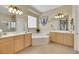 Bright bathroom with double sinks, a jetted tub, and a separate glass-enclosed shower at 2756 Strathblane Ave, Henderson, NV 89044