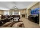 Cozy living room featuring a fireplace, leather furniture, a ceiling fan, and large windows offering natural light at 2756 Strathblane Ave, Henderson, NV 89044