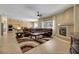 Open-concept living room with a kitchen view, a large leather sectional, tile floors, and a modern fireplace at 2756 Strathblane Ave, Henderson, NV 89044