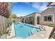 Serene backyard featuring a sparkling pool, spa, covered patio, and lush landscaping at 2756 Strathblane Ave, Henderson, NV 89044