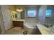 Bright bathroom featuring double vanity, soaking tub, and tile floors at 2764 Leys Burnett Ave, Henderson, NV 89044