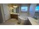 Bright bathroom featuring double vanity, soaking tub, and tile floors at 2764 Leys Burnett Ave, Henderson, NV 89044