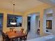 Elegant dining room with a chandelier, wood table set, and view into the living area at 2764 Leys Burnett Ave, Henderson, NV 89044